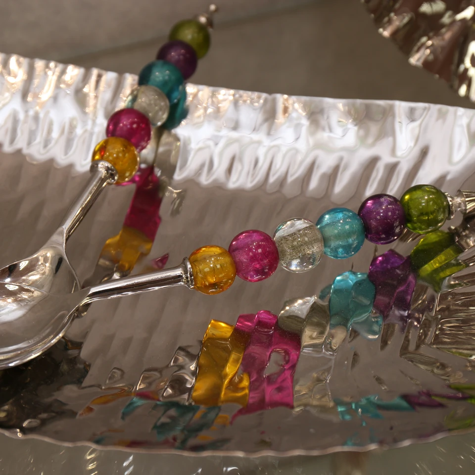 Colourful beaded serving pieces on a silver tray